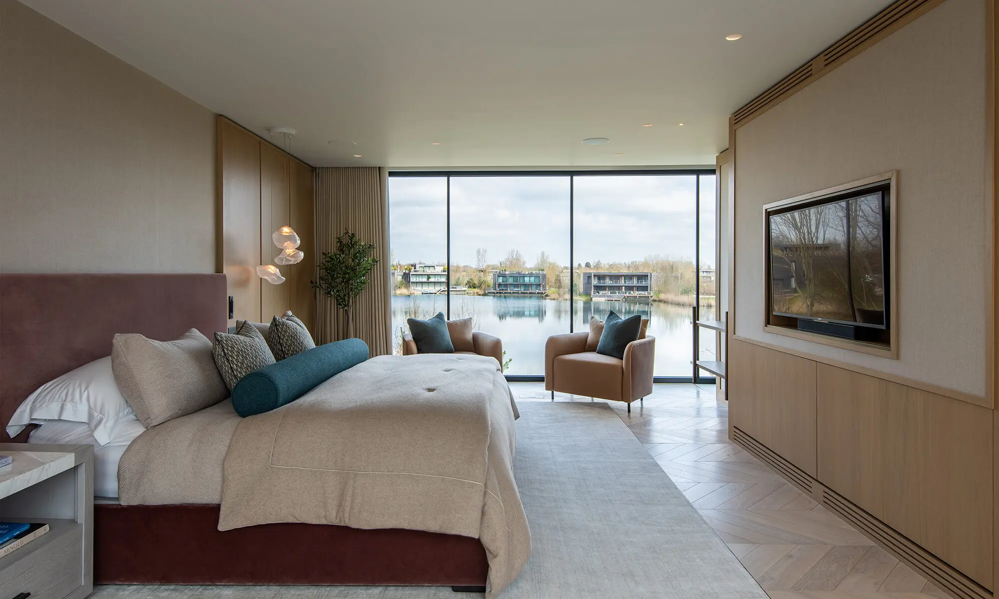 Bedroom with large bed and neutral coloured furnishings
