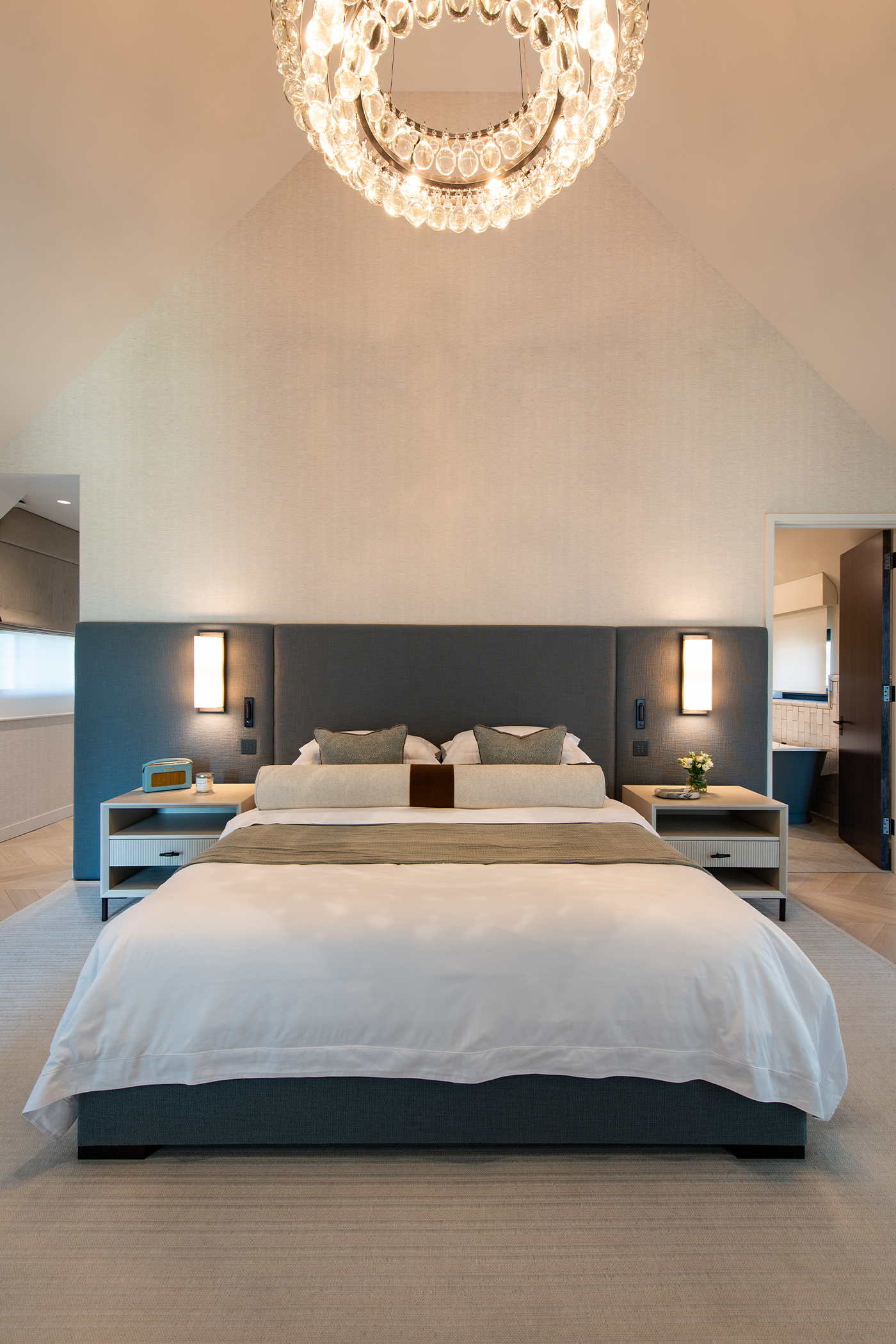 Grand master bedroom with bed and modern chandelier