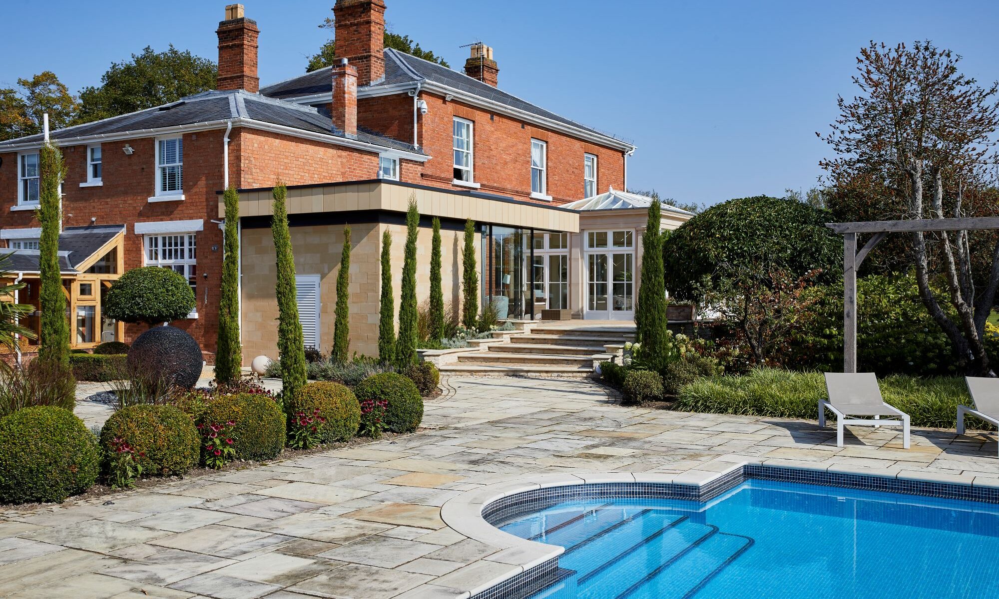 A swimming pool in front of a house.